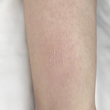 Белая татуировка с китайским иероглифом