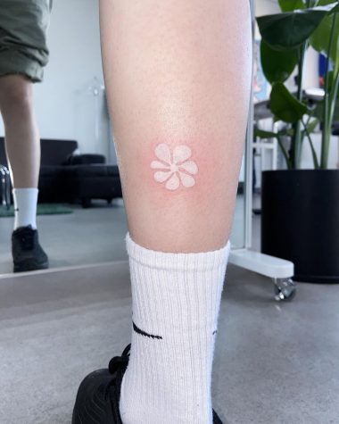 Белая тату цветка на ноге