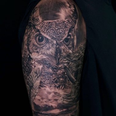 Черно-белая сова на плече у парня