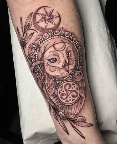 Татуировка совы с украшениями на руке