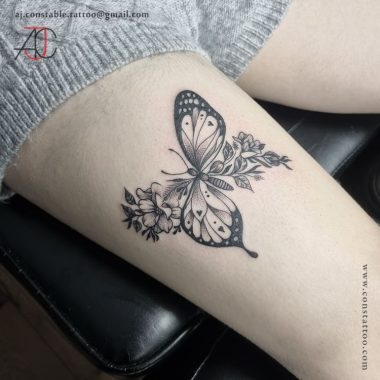 Бабочка с цветками, женская тату на бедре