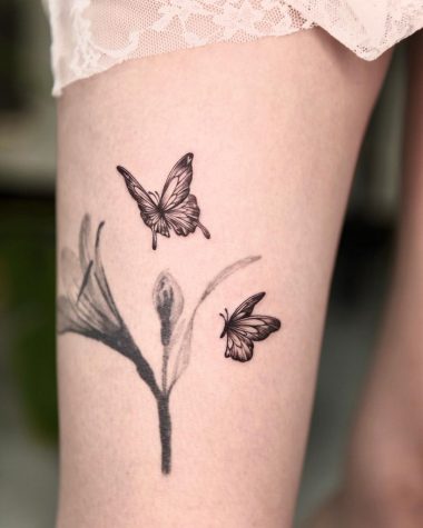 Две бабочки и цветок, тату на бедре у девушки
