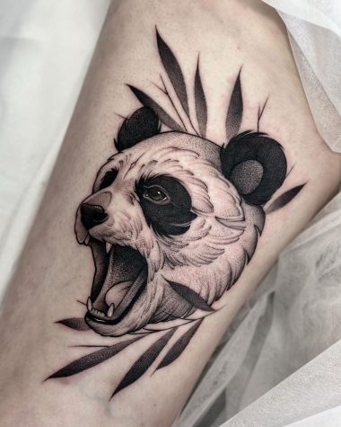 Графичная татуировка панды на бедре