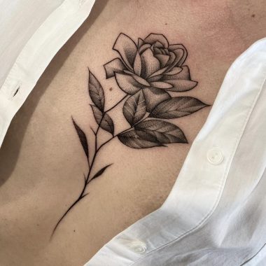 Татуировка роза в стиле графика на груди у девушки