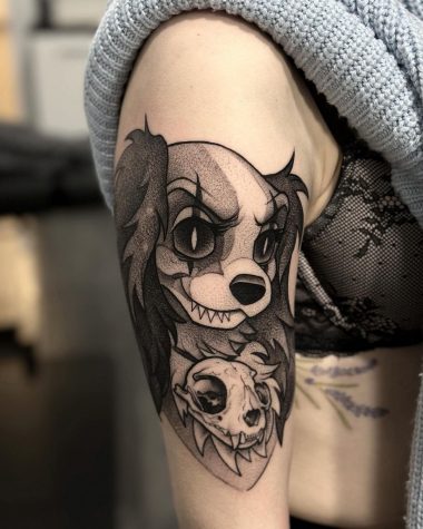 Татуировка собака с черепом в стиле графика на плече у девушки
