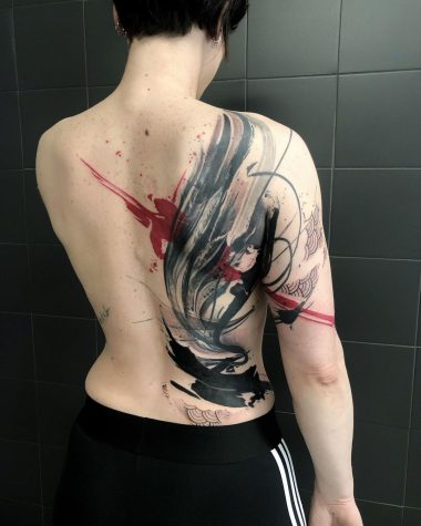 Женская тату на спине в стиле трэш-полька
