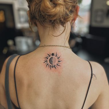 Необычная тату солнца на спине у девушки