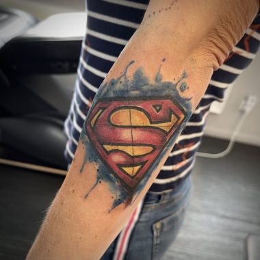 Символ Супермена, акварельная тату на предплечье