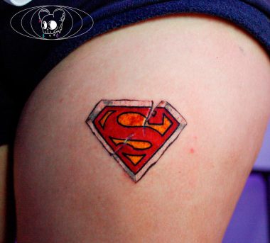 Символ Супермена, женская тату на бедре