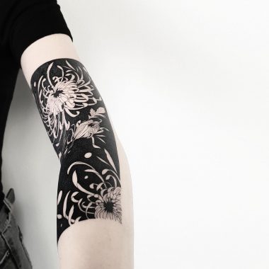 Белые хризантемы на черном фоне, тату на руке