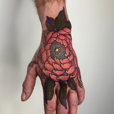 Цветок хризантемы на кисти руки у парня