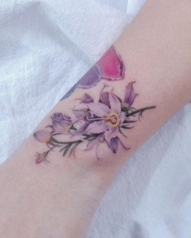 Татуировка фиолетовых лилий на запястье