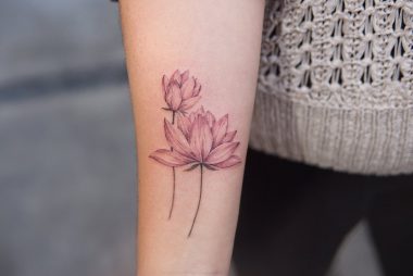 Розоватые цветы лотоса, татуировка на предплечье