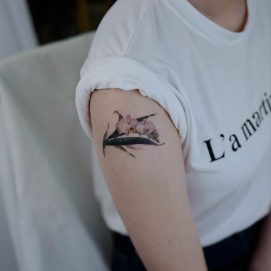 Татуировка орхидеи на плече у девушки