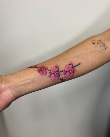 Розовые орхидеи, тату на руке у девушки