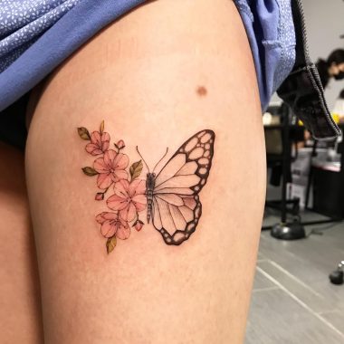 Бабочка с цветами сакуры, женская тату на бедре