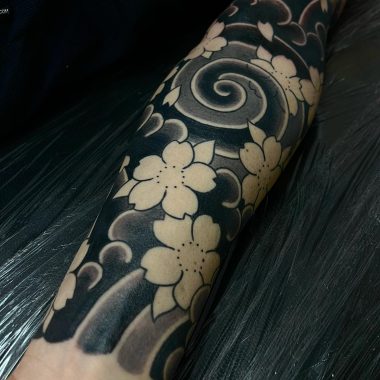 Черная японская тату с цветками сакуры на руке