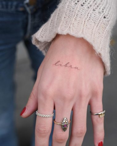 Надпись Libra на кисти руки у девушки