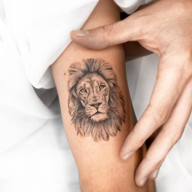 Татуировка льва на руке у девушки